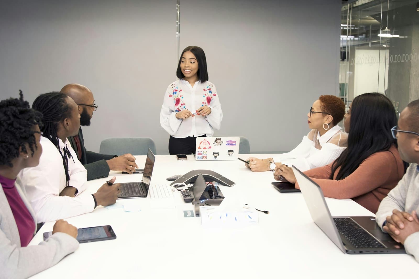 Líder africana a apresentar à sua equipa reunida à volta de uma mesa de conferência